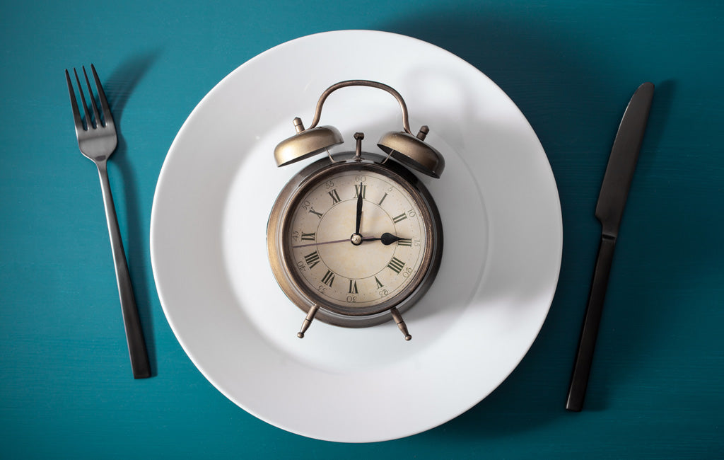  clock on a plate surrounded by knife and fork
