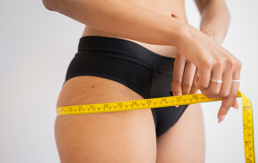  woman measuring her waist