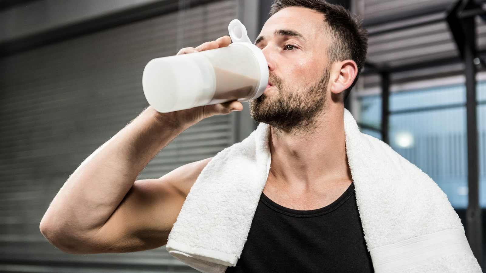  Man drinking a protein shake in moderation after workout