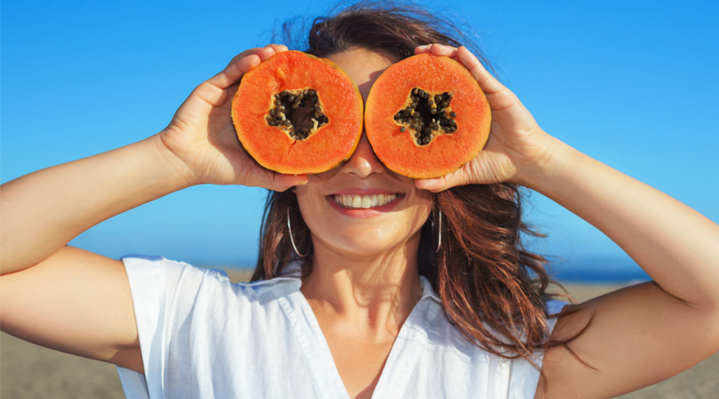  Woman using papaya slices as glasses