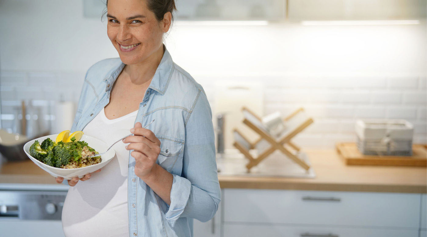 pregnant woman eating green veggies