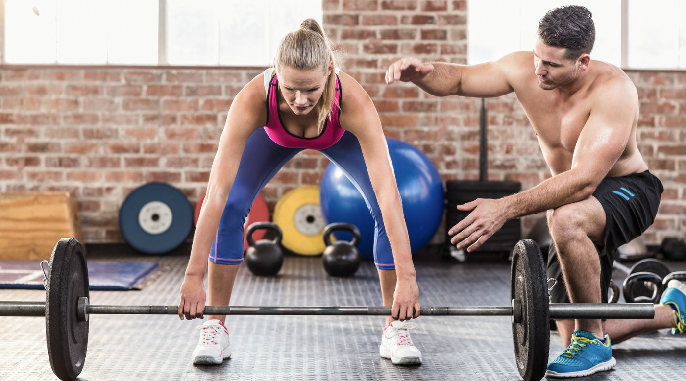  woman with trainer in cross fit gym